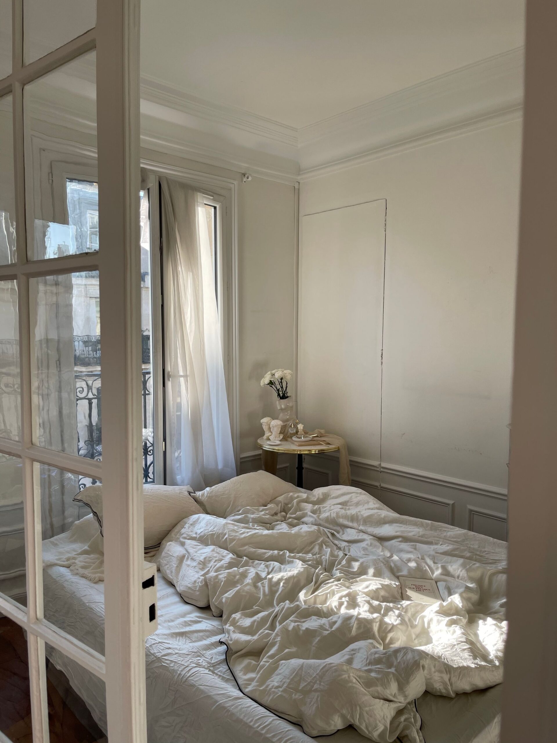 Made bed in morning light after a bedroom cleaning